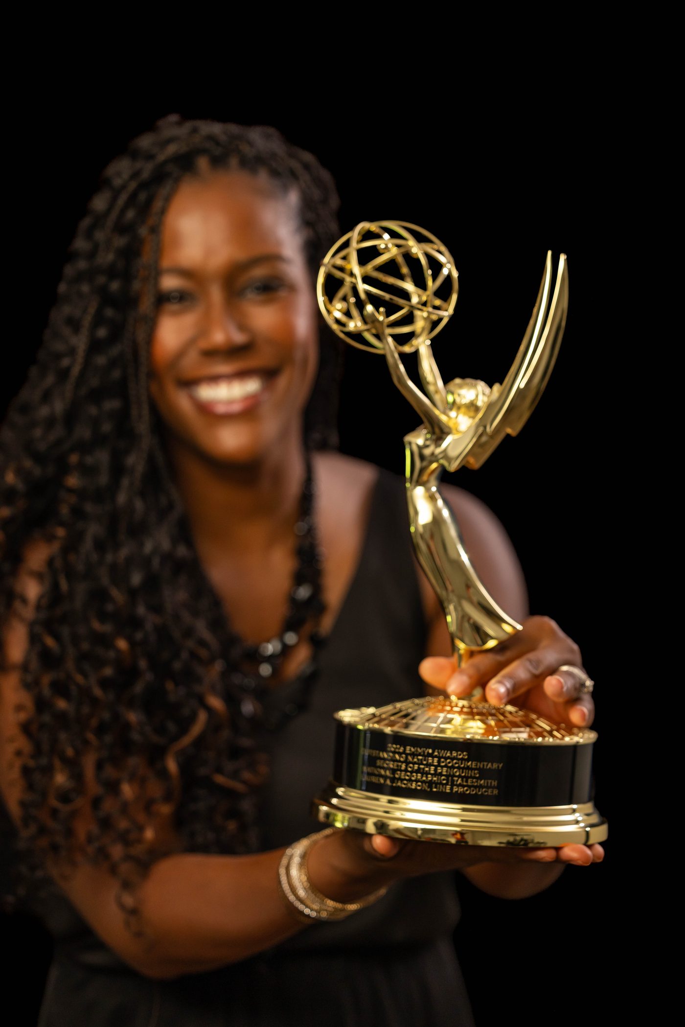 Lauren A. Jackson holding her Emmy Award for Secrets of the Penguins